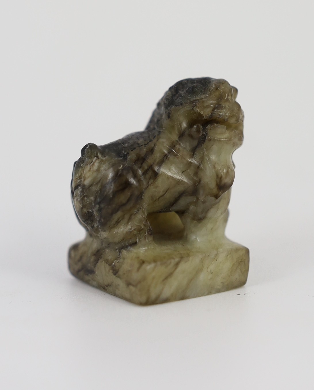 A Chinese pale celadon and black jade ‘lion-dog’ seal, 18th/19th century, 3.9cm high